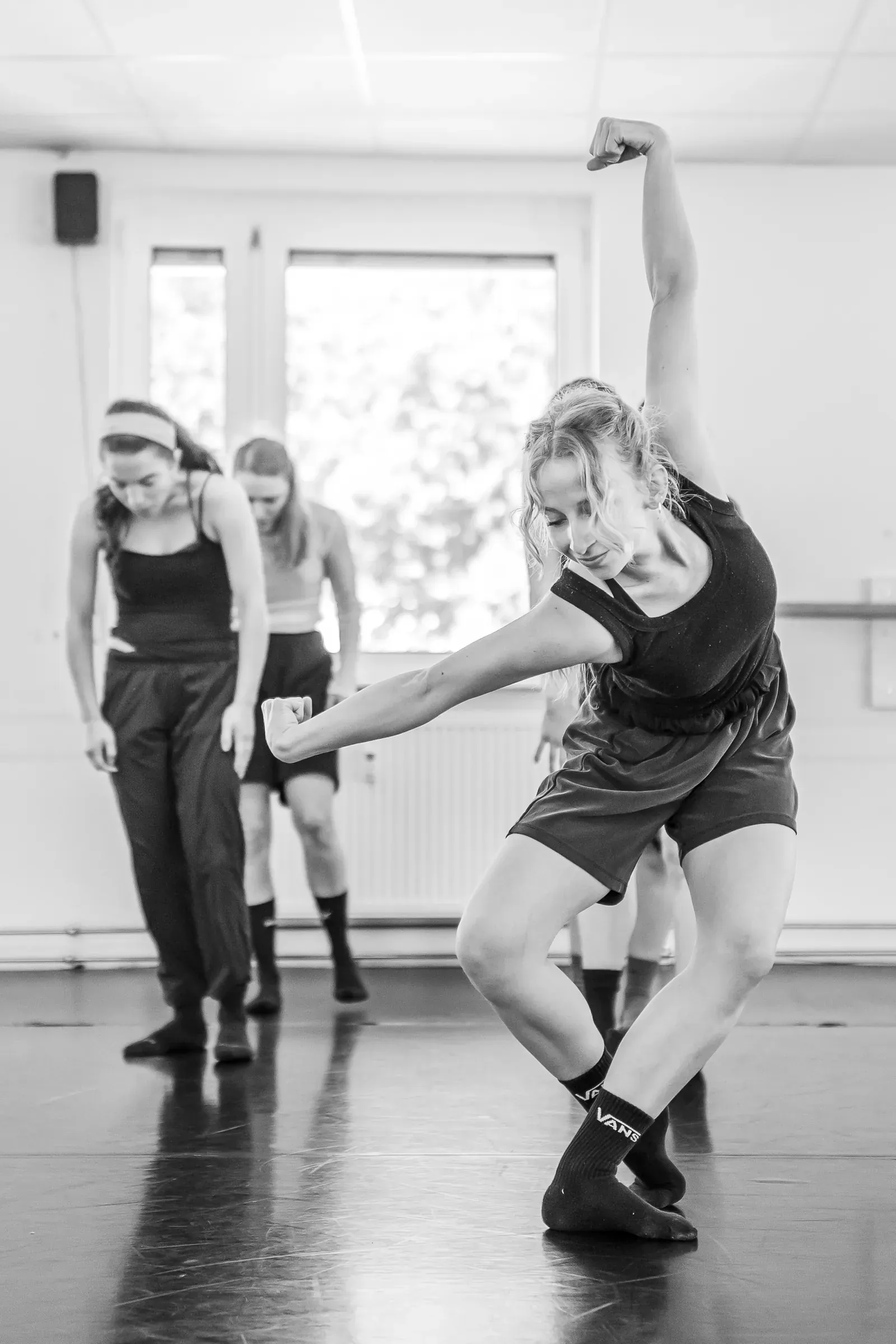Lucie Marcellin in a grounded movement during a company rehearsal (black and white)