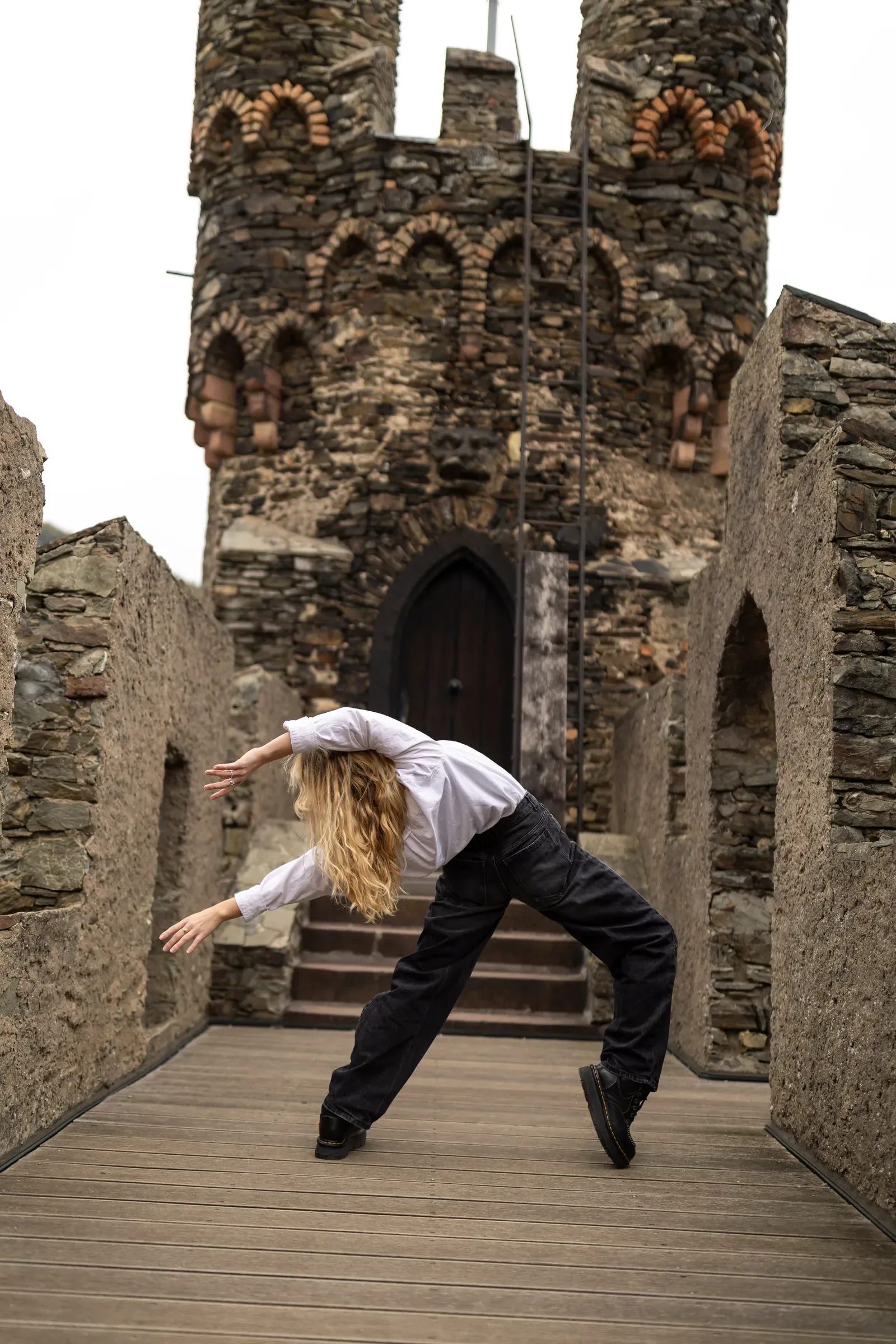 Lucie Marcellin in a side bend in front of a castle tower
